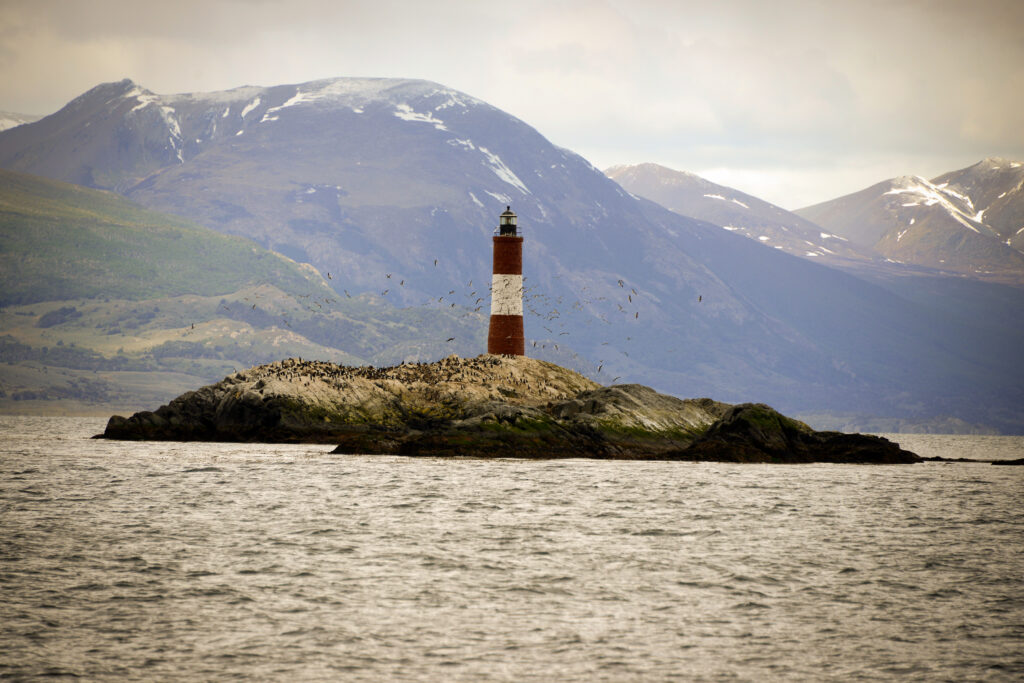 Phare rouge et blanc sur un îlot rocheux du canal de Beagle près d'Ushuaia
