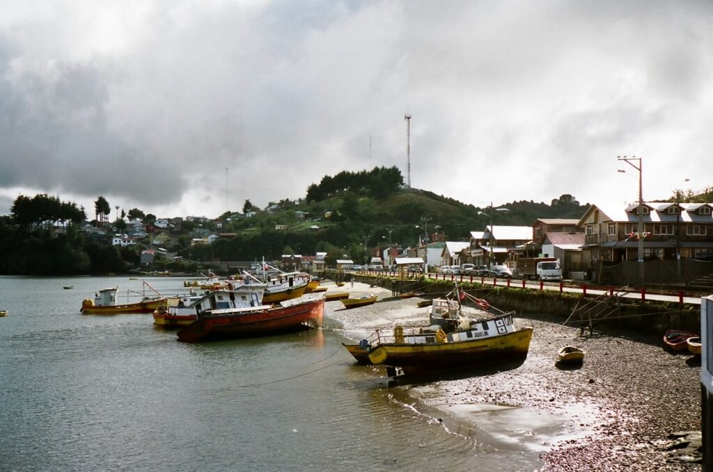 Bateaux de pêche colorés échoués à marée basse dans un village côtier de Chiloé, Chili