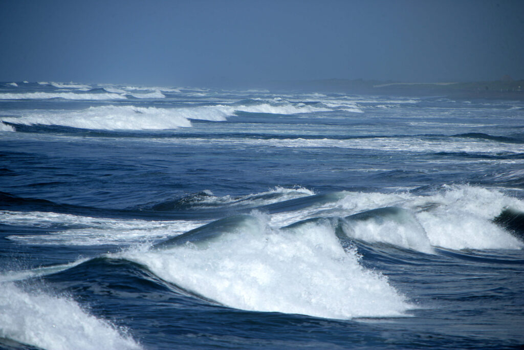 Vagues bleues déferlant en écume blanche sur l'océan, sans plage ni sable visible