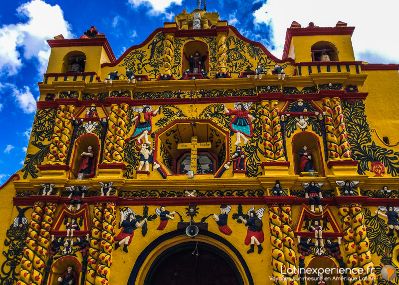 Façade jaune ornée de statues et motifs colorés de l'église de San Andrés Xecul, Guatemala