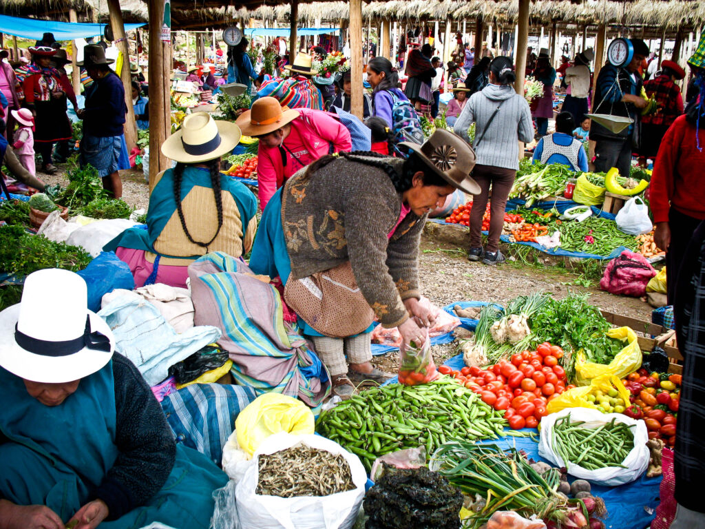 Marché de légumes animé avec vendeuses en chapeaux traditionnels, tomates et haricots verts, région de Cusco, Pérou