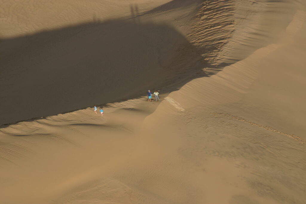 Randonneurs traversant les dunes de sable côtières près de La Pedrera, Uruguay