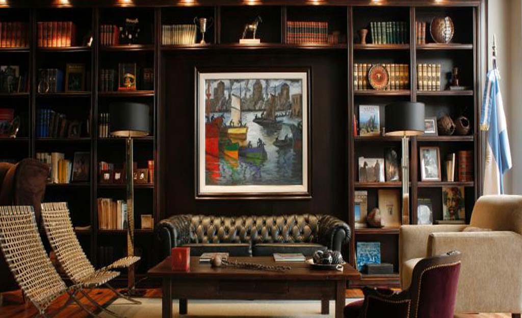 Salon bibliothèque cosy à Buenos Aires avec canapé en cuir, tableau et drapeau argentin