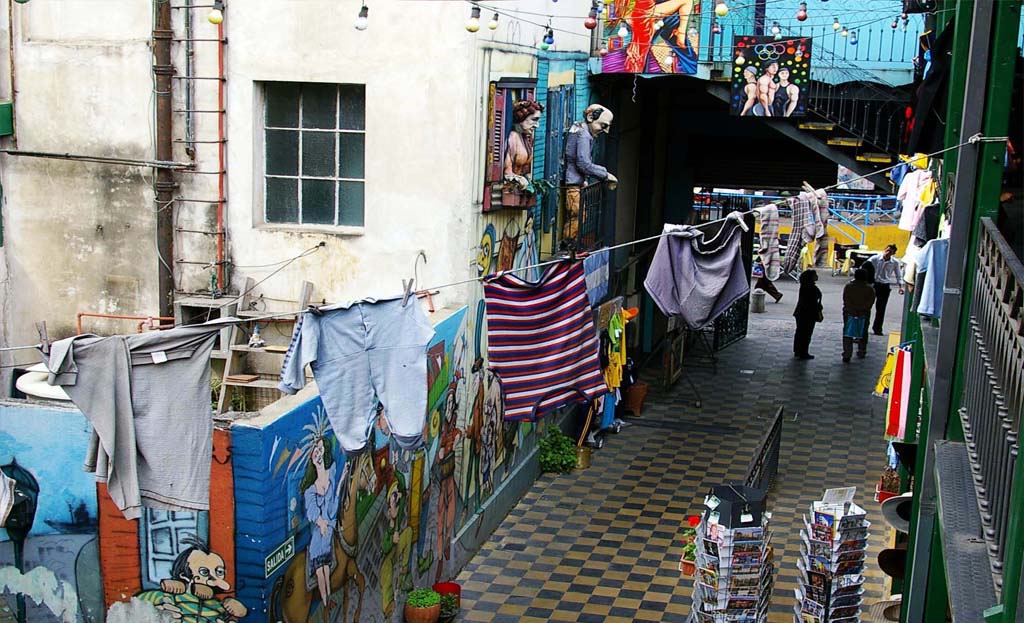 Passage animé de La Boca avec linge suspendu et façades peintes à Buenos Aires