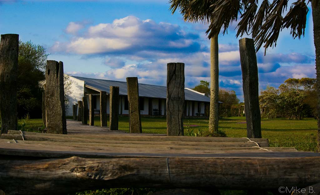 Passerelle en bois menant à un bâtiment blanc dans les Esteros del Iberá, Argentine
