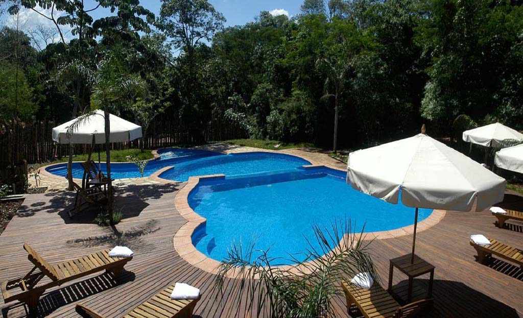 Piscine sinueuse avec transats et parasols entourée de forêt subtropicale près d'Iguazu, Argentine