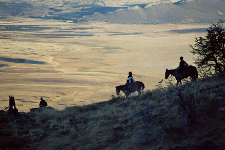 Cavaliers à cheval surplombant la steppe patagonienne au coucher du soleil près d'El Calafate, Argentine