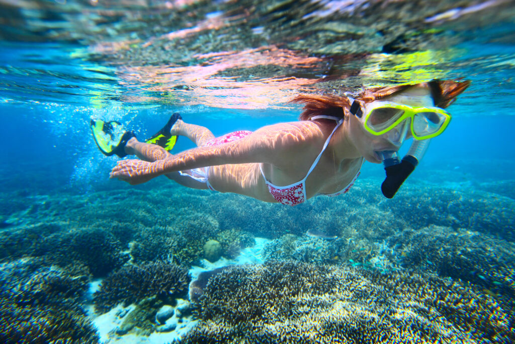 Femme faisant du snorkeling au-dessus d'un récif corallien dans les eaux des îles Cayman