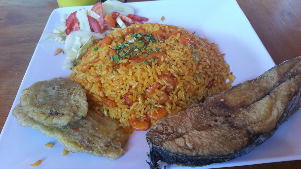 Assiette de poisson frit, riz aux crevettes, patacones et salade, cuisine colombienne typique