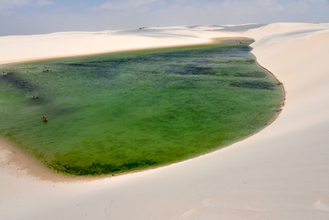 Vue aérienne d'une lagune verte entourée de dunes de sable blanc, Lençóis Maranhenses, Brésil