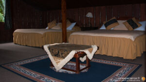 Chambre rustique avec deux lits et table basse en bois à Mindo