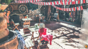 Terrasse de café décorée avec guirlandes rouges et tables en bois