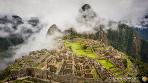 Machu Picchu entouré de nuages et montagnes verdoyantes au Pérou