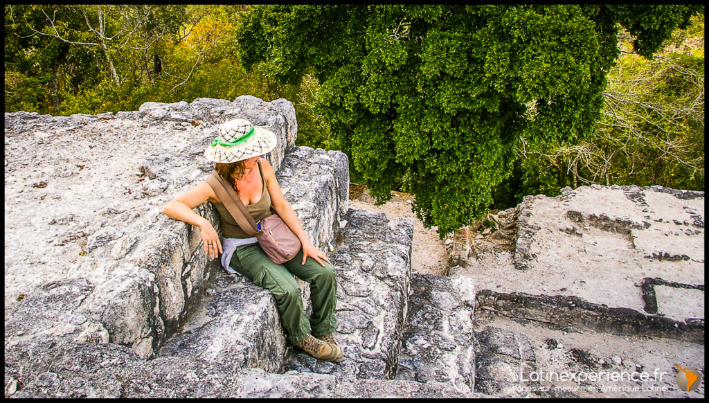 Femme assise sur les pierres d'une pyramide maya au sommet de Calakmul, Mexique