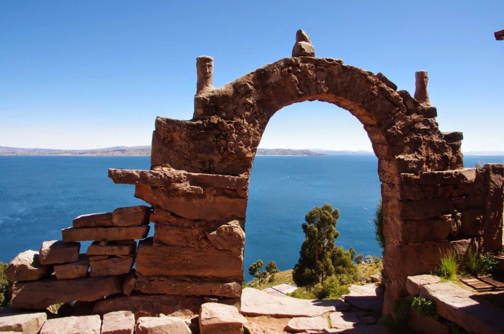 Arche en pierre sculptée surplombant le lac Titicaca, sans bateau visible