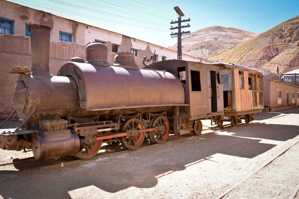 Locomotive à vapeur rouillée et wagon en bois abandonnés à Pulacayo, ancienne cité minière bolivienne