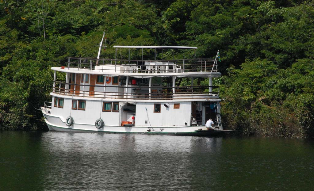 Bateau à cabines amarré près de la rive boisée d'une rivière amazonienne au Brésil