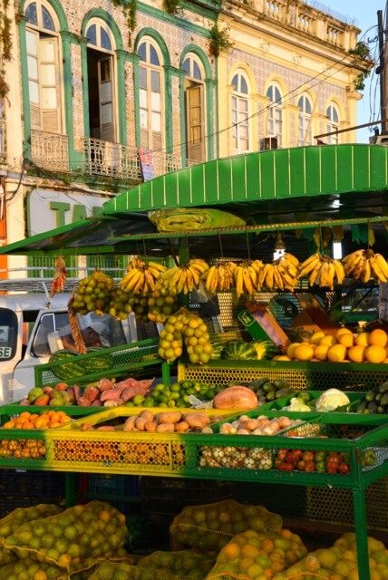 Étal de fruits colorés devant façade coloniale à Belém, Amazonie brésilienne