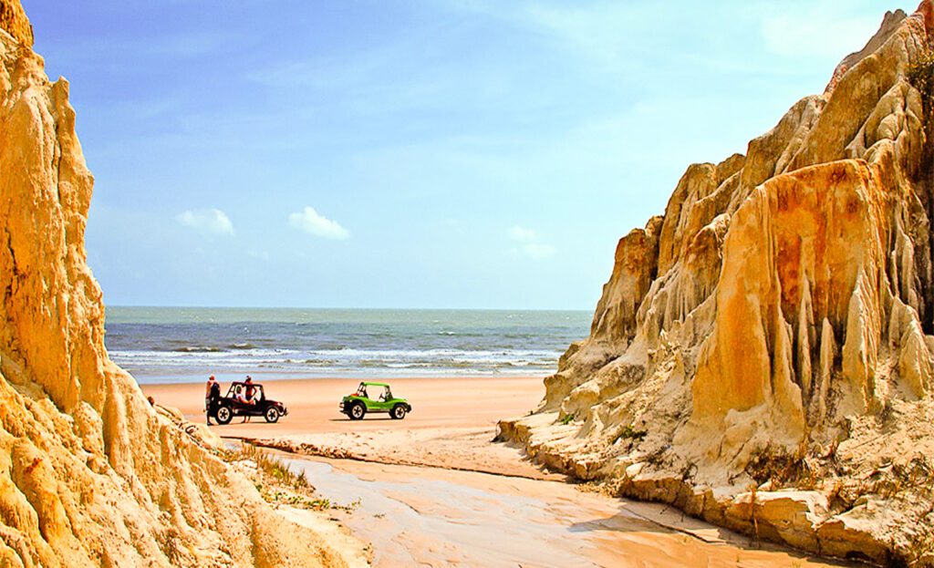 Deux buggys arrêtés sur la plage entre falaises érodées à Pontal do Maceio, Brésil