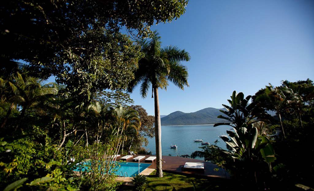 Piscine surplombant la baie de Paraty, entourée de végétation tropicale et de montagnes boisées