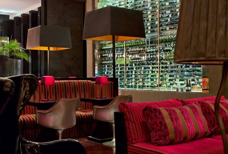 Bar lounge avec cave à vin vitrée, fauteuils design et banquettes rayées rouge et or, Chili