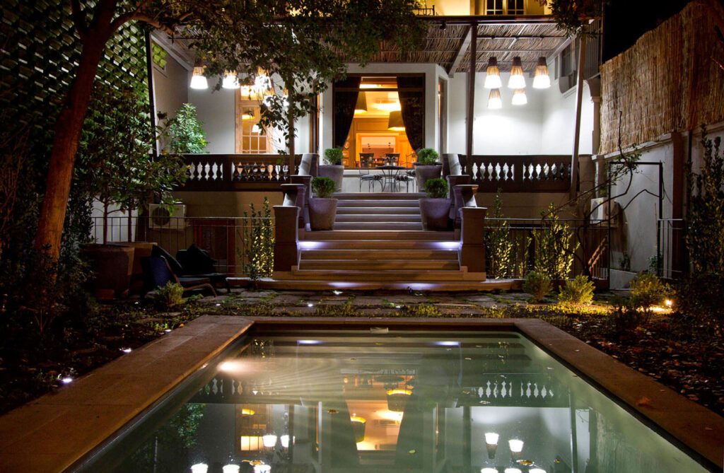 Piscine et terrasse illuminées d'un hôtel de charme à Santiago du Chili, la nuit