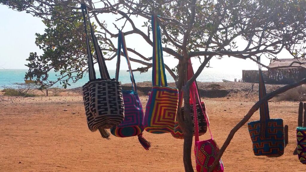 Sacs traditionnels Wayuu colorés suspendus à un arbre près de la plage, Alta Guajira, Colombie