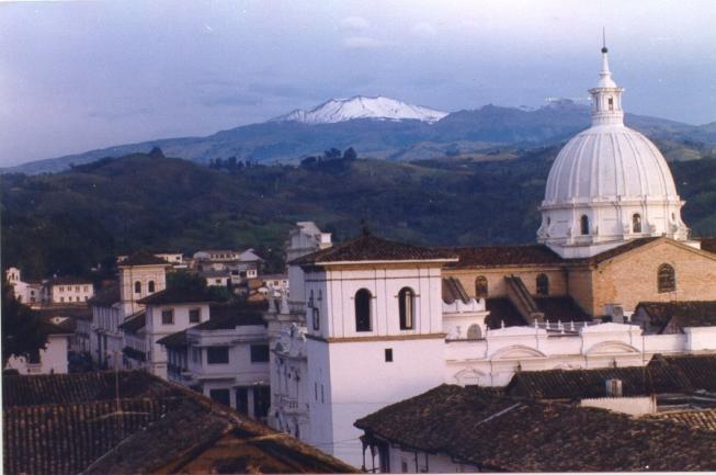 Vue sur les toits de Popayán avec dôme d'église blanc et volcan enneigé en arrière-plan, Colombie