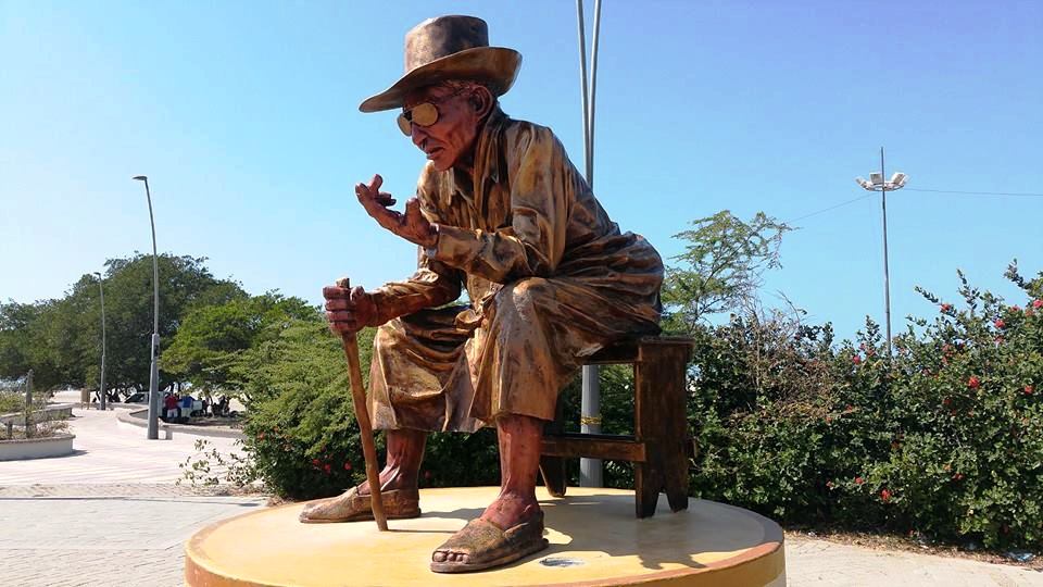Statue en bronze d'un vieil homme assis avec canne à Riohacha, Colombie