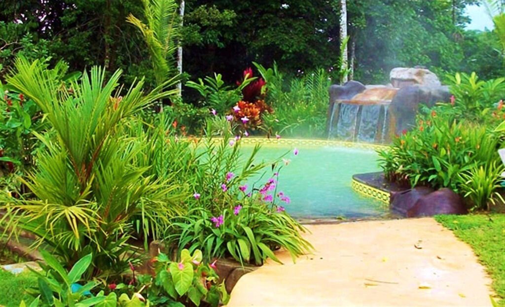 Piscine thermale aménagée avec cascade artificielle entourée d'un jardin tropical, Rincón de la Vieja, Costa Rica