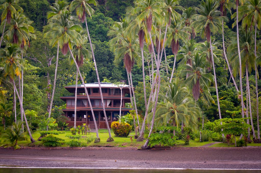 Maison à étages en bois entourée de palmiers en bordure du Golfo Dulce, Costa Rica