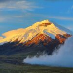 Volcan Cotopaxi enneigé au lever du soleil entouré de nuages, Equateur
