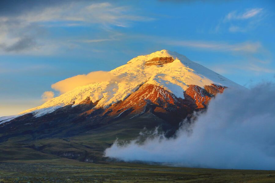Volcan Cotopaxi enneigé au lever du soleil entouré de nuages, Equateur