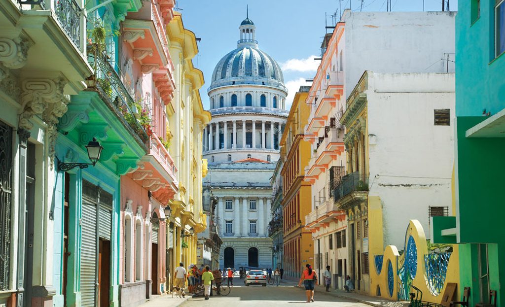 Rue colorée de La Havane avec vue sur le dôme du Capitole, façades pastel et passants