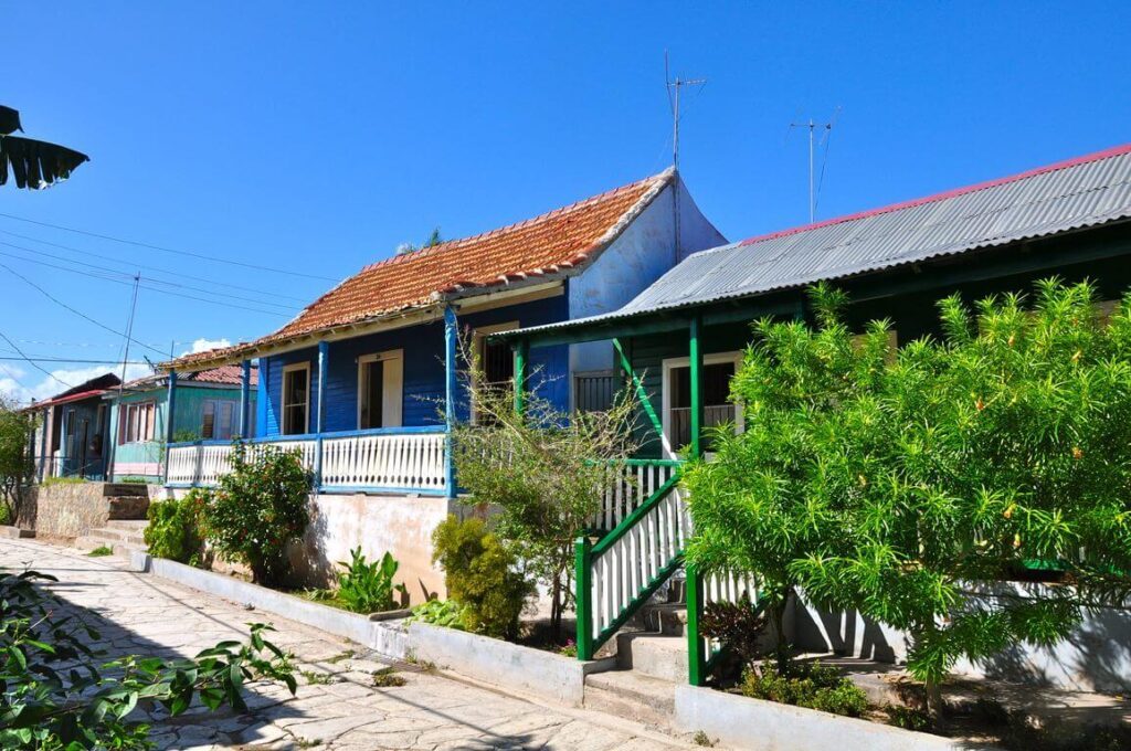 Maison en bois bleue avec véranda et toit de tuiles dans une rue de Cuba