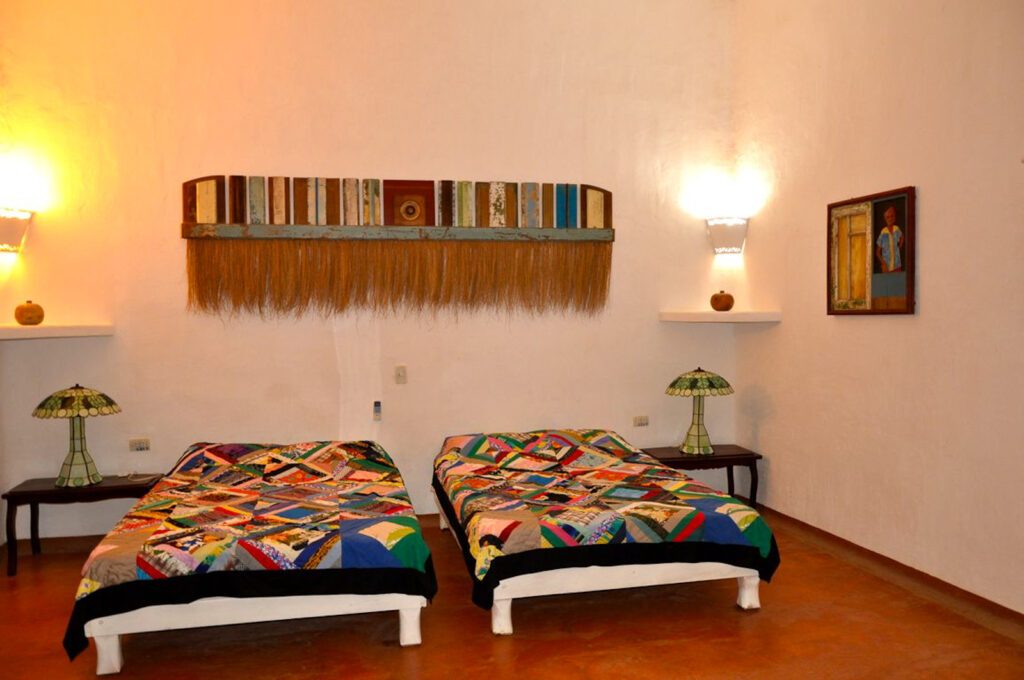 Chambre à Trinidad, Cuba, deux lits jumeaux avec couvre-lits patchwork colorés et décoration artisanale