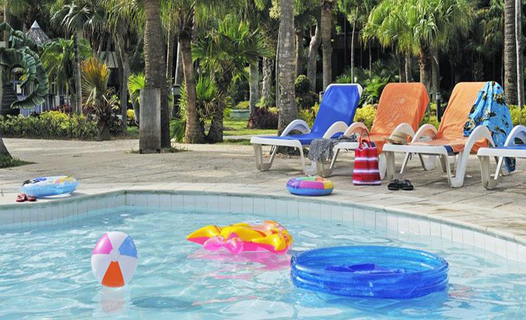 Piscine d'hôtel avec bouées et jouets flottants, transats et palmiers à Varadero, Cuba