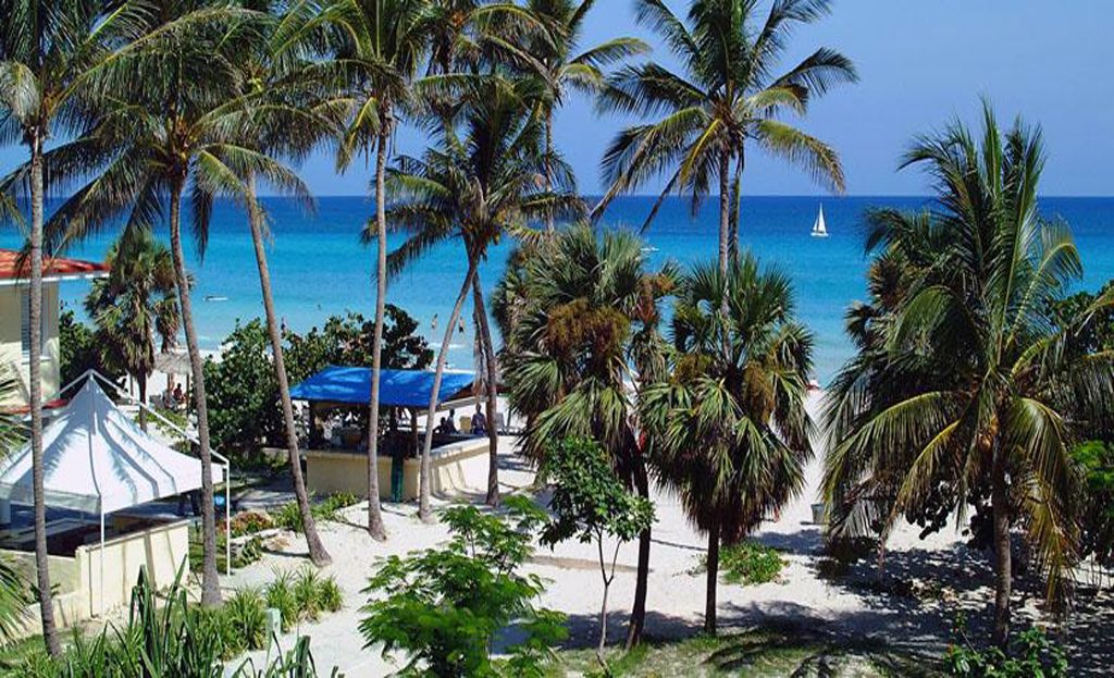 Plage de Varadero avec palmiers, sable blanc et mer turquoise vue depuis un hôtel
