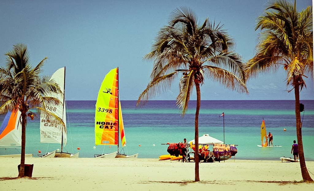 Plage de Varadero à Cuba avec voiliers Hobie Cat, palmiers et planche à voile sur mer turquoise