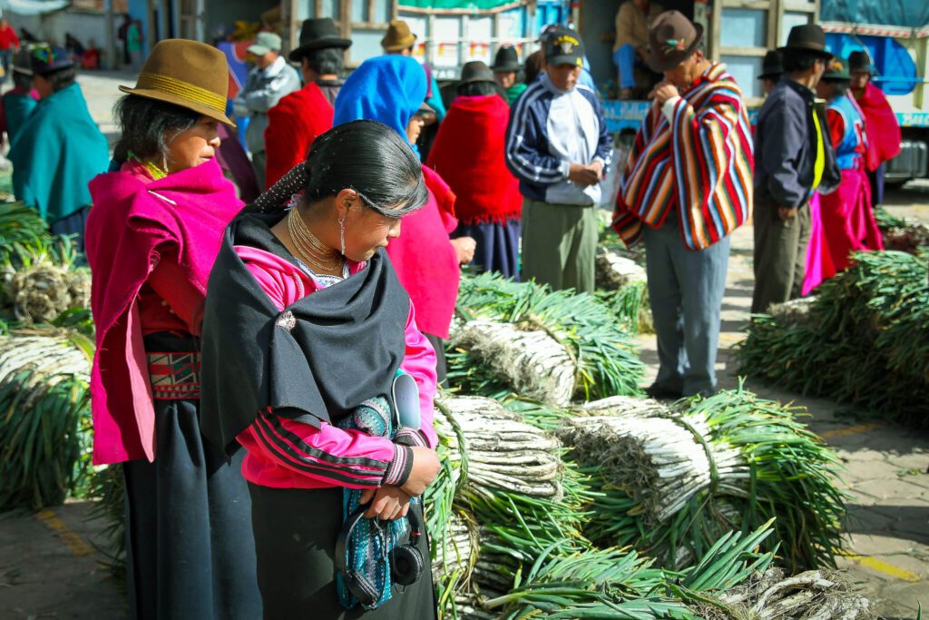Marché de produits agricoles à Otavalo, vendeurs en tenue traditionnelle andine colorée, Equateur