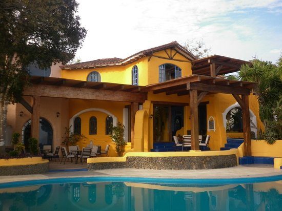 Bâtiment jaune de style colonial avec piscine et terrasse en bois, Parc National de Machalilla, Équateur