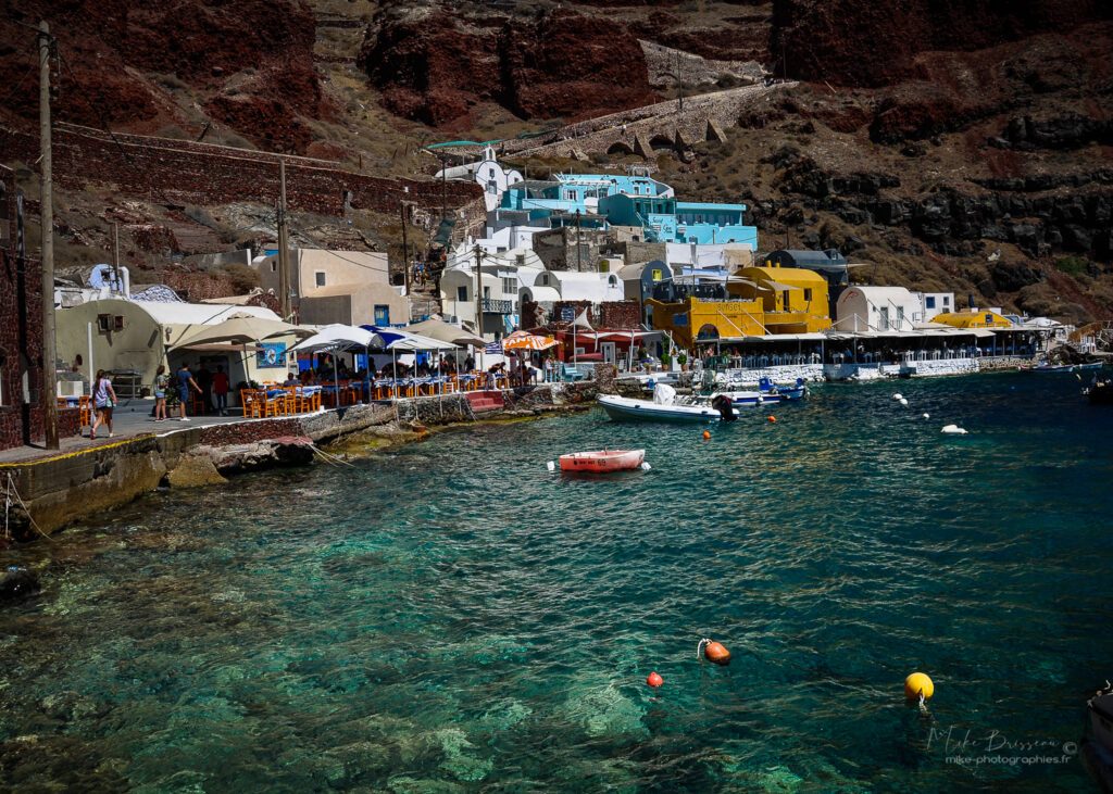 Port coloré de Santorin avec bateaux et maisons au bord de l'eau