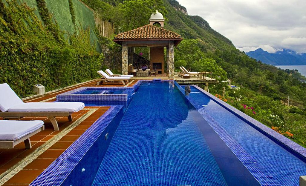 Piscine à débordement bleue avec transats et pavillon surplombant le lac Atitlán, Guatemala