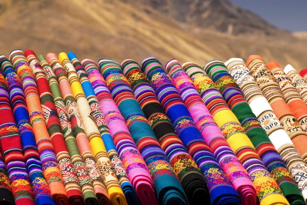 Rouleaux de tissus colorés aux motifs traditionnels exposés en plein air, Guatemala