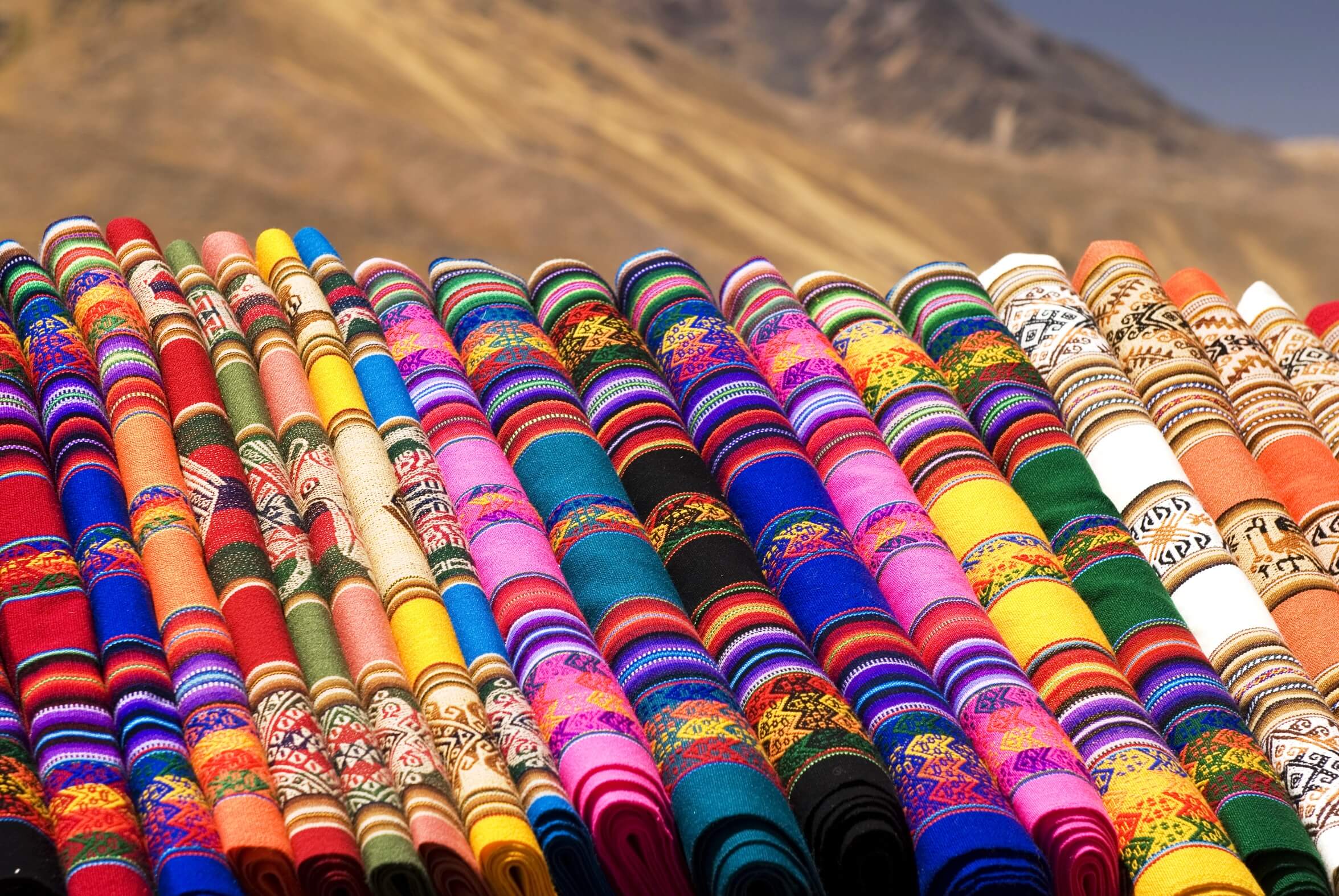Rouleaux de tissus colorés aux motifs traditionnels exposés en plein air, Guatemala