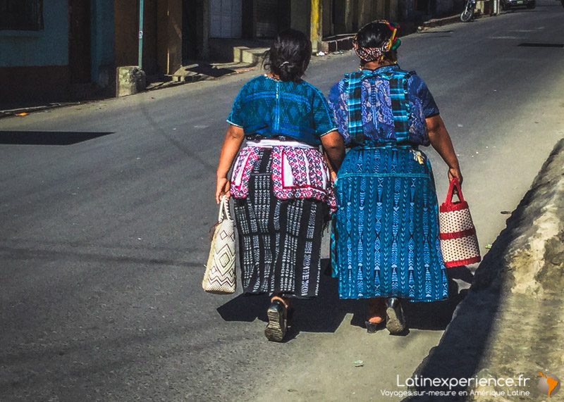 Deux femmes en tenue traditionnelle maya marchent dans une rue au Guatemala