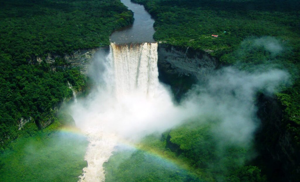 Vue aérienne des chutes Kaieteur au Guyana, cascade encaissée entourée de jungle avec un arc-en-ciel