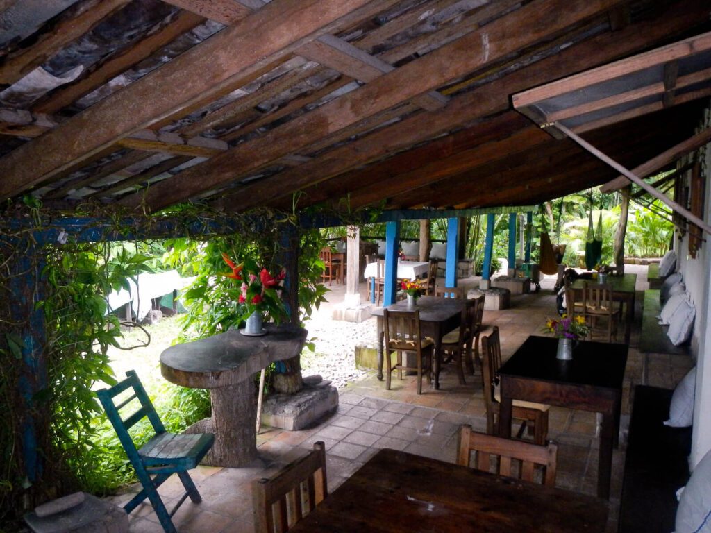 Terrasse couverte en bois avec tables, chaises et fleurs, hacienda à Copan, Honduras