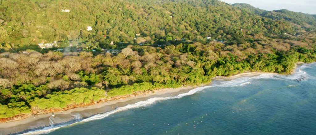 Vue aérienne d'une côte forestière avec petite plage et habitations dispersées, péninsule de Nicoya, Costa Rica