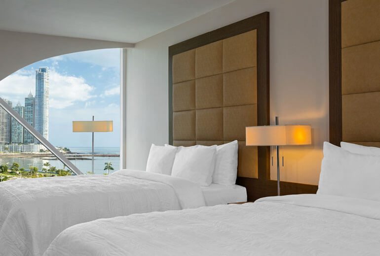 Chambre d'hôtel avec deux lits doubles et vue sur les gratte-ciel de Panama City